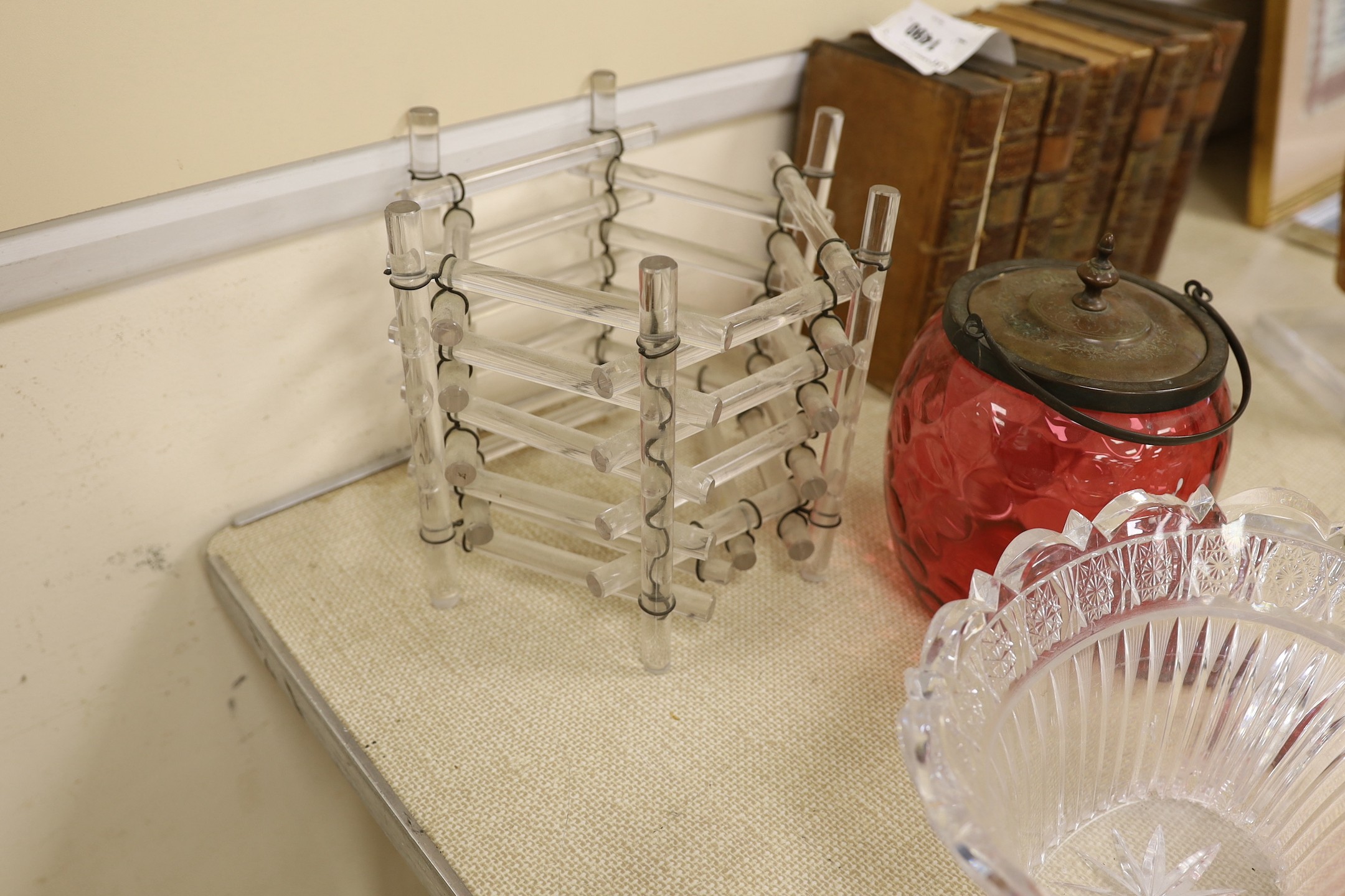 An abstract glass plant pot holder, together with a pair of cranberry glass jars and covers, etc.